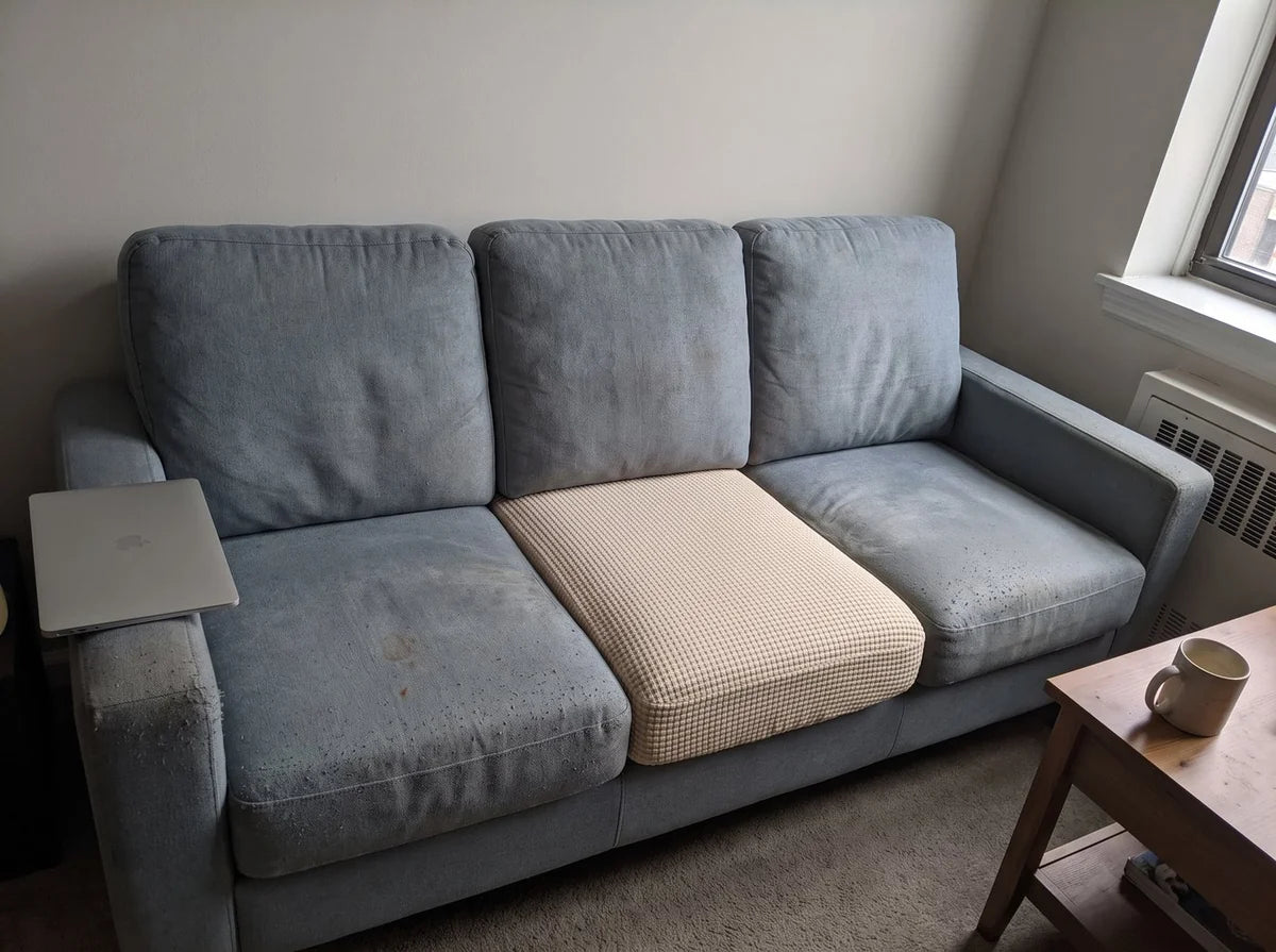 One cream Avelo Casa cover on the middle cushion of a sofa, the other two uncovered