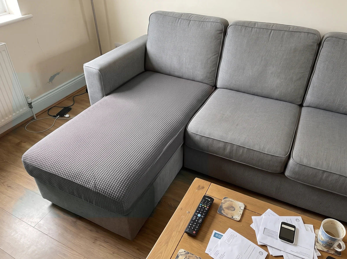 The chaise cushion of an L-shaped sofa fitted with a medium grey Avelo Casa cover, the rest of the sofa uncovered